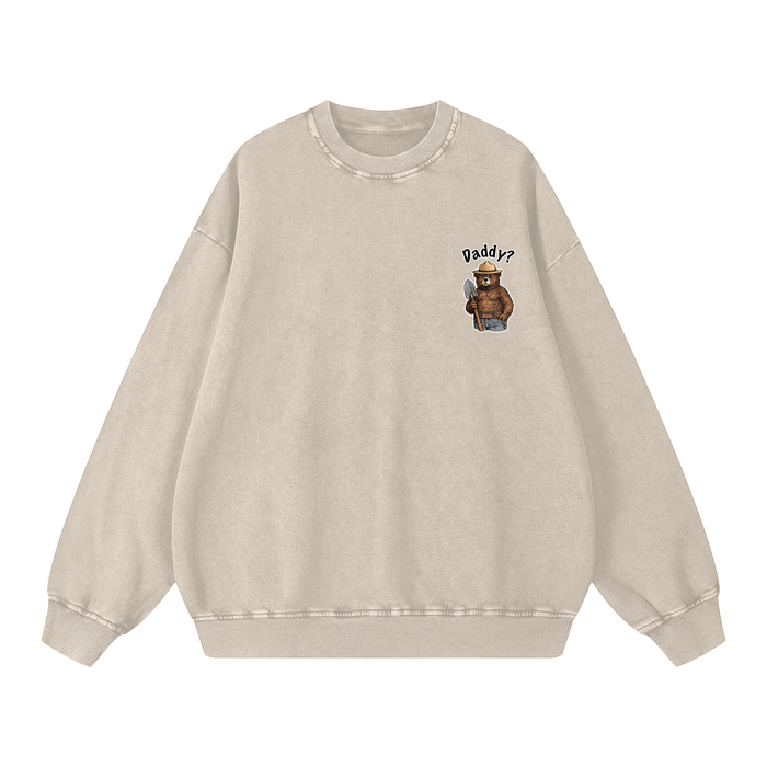A light beige crewneck sweatshirt with a small graphic on the left chest showing an outdoor bear wearing a hat and the text 'Daddy?'.