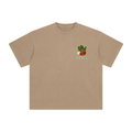 A light brown short-sleeve crewneck t-shirt with a small graphic on the left chest showing an apple.