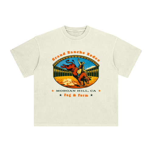 An off-white short-sleeve t-shirt with a vintage-style graphic of a cowboy riding a bucking bull in a rodeo arena in South Bay.