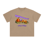 A tan crewneck t-shirt featuring a graphic of a cartoonish Stone Age house, with the text 'YADADAMEAN?' above.