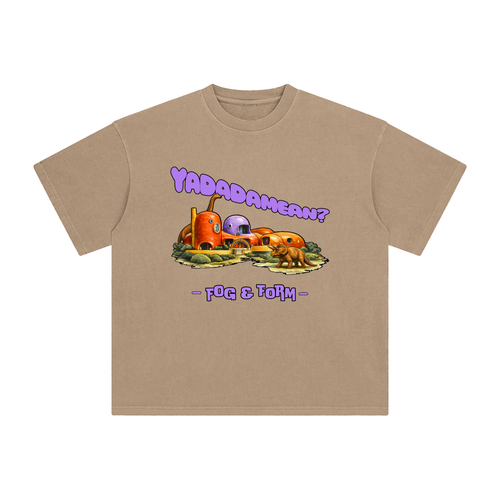 A tan crewneck t-shirt featuring a graphic of a cartoonish Stone Age house, with the text 'YADADAMEAN?' above.